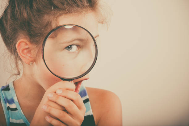 istock Little girl kid looking through magnifying glass. 1194300907