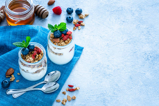 istock Healthy food: homemade yogurt and granola on blue table. Copy space 1194302194