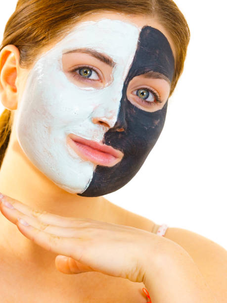 istock Girl with black white mud mask on face 1194302196