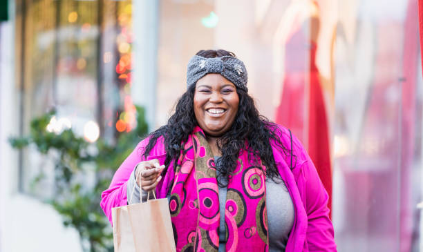 donna afroamericana fuori negozio - focus on foreground joy happiness pink foto e immagini stock