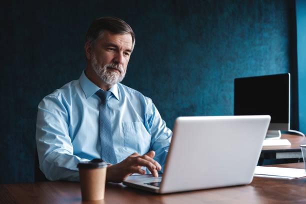 istock Senior man in office working on laptop computer 1194305630