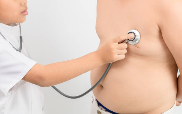маленькая рука врач проверить сердце стетоскопом ожирением азиатский мальчик - overweight child little boys diabetes стоковые фото и изображения