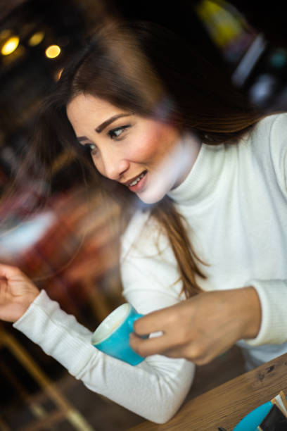 istock Female Asian drinking coffee in a coffeehouse 1194306804