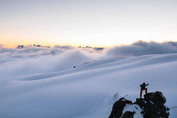 istock Mountaineer prepares climbing equipment on mountain peak 1194308179