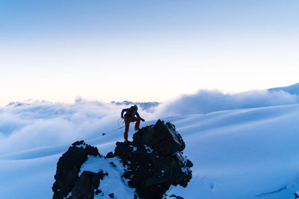 istock Mountaineer prepares climbing equipment on mountain peak 1194308201