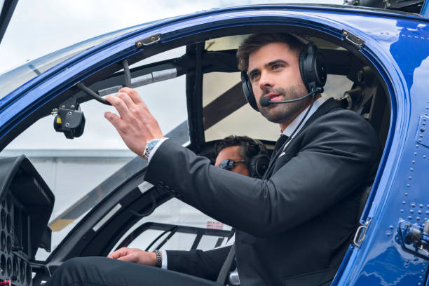 istock Latin executive coopilot man in a beautiful blue helicopter opens one of its doors to get rid of the helicopter dressed in formal suit and next to it the official helicopter pilot 1194308253