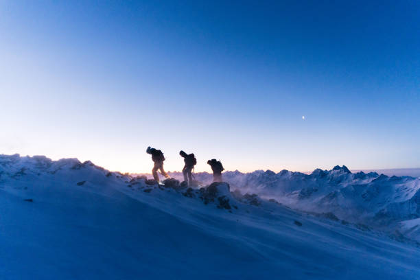 istock Mountaineers ascend snowy ridge at sunrise 1194308341