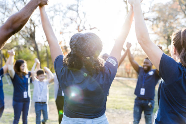 istock Volunteers raise hands in unity during 1194308431