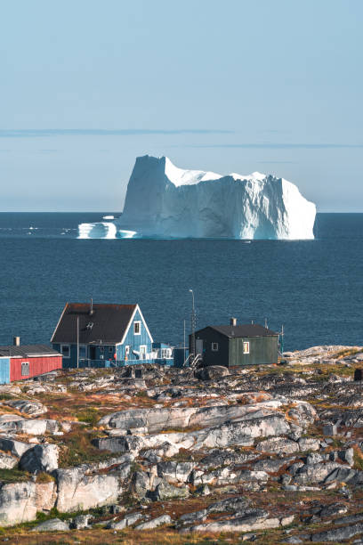 maisons en bois bleu vert colorées avec des icebergs à l'arrière-plan. rodebay, également connu sous le nom d'oqaatsut est une colonie de pêche au nord d'ilulissat. disco bay et qeqertarsuaq. ciel bleu et soleil. - greenland inuit house arctic photos et images de collection
