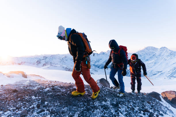 istock Mountaineers ascend snowy ridge at sunrise 1194309593