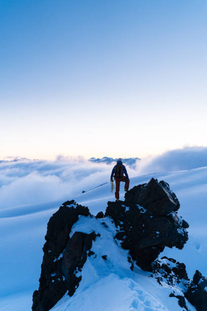 istock Mountaineer prepares climbing equipment on mountain peak 1194309719