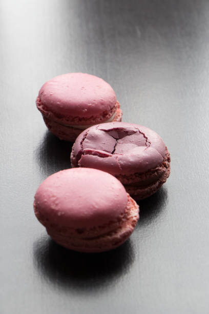 istock Pink macaroons, french biscuit dessert, sweets at black background 1194310327