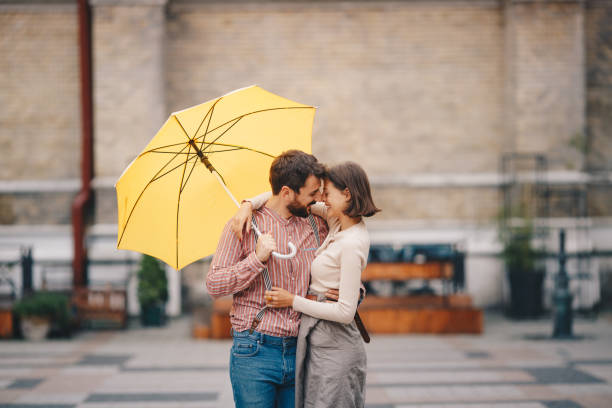 istock Young couple embracing under umbrella. 1194311820