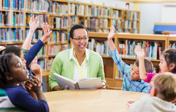 istock Teacher reading to children in library 1194313174