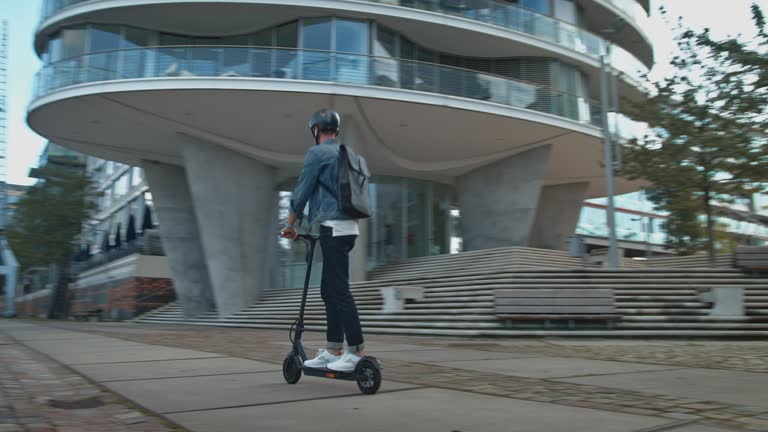 Male riding electric kick scooter in city