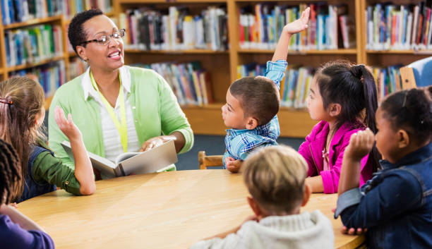istock Teacher reading to children in library 1194313178
