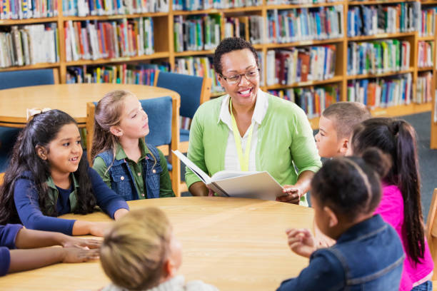 istock Teacher reading to children in library 1194314281