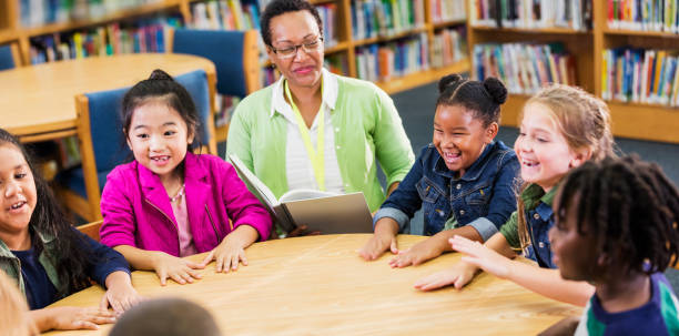 istock Teacher reading to children in library 1194314806