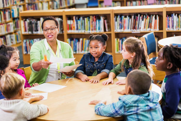 istock Teacher passing out paper to elementary school class 1194314896