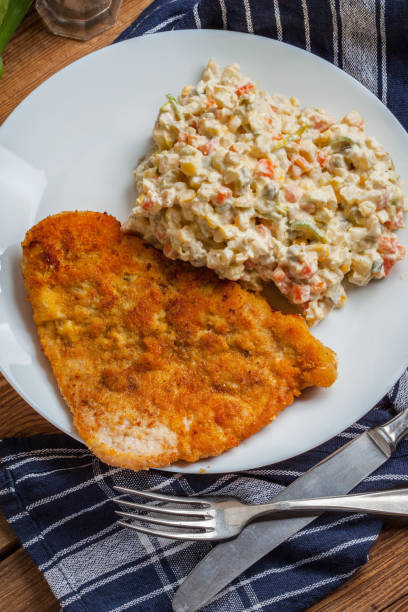 istock Fried pork chop in breadcrumbs, served with vegetable salad. 1194314960