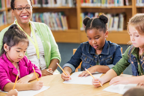 istock Teacher with elementary school girls writing 1194315085