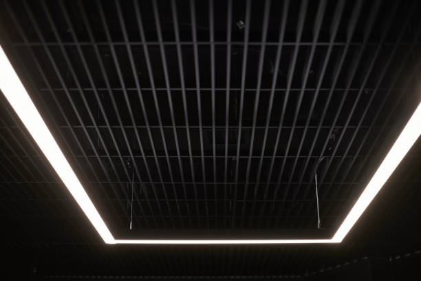 istock Modern office lighting. Thin lamps in office dark ceiling. LED white cold light over workplaces. 1194315151