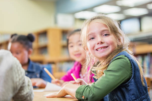 istock Girl and elementary school classmates writing 1194315391