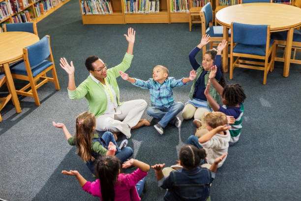 istock Teacher, elementary school students sitting in circle 1194315591