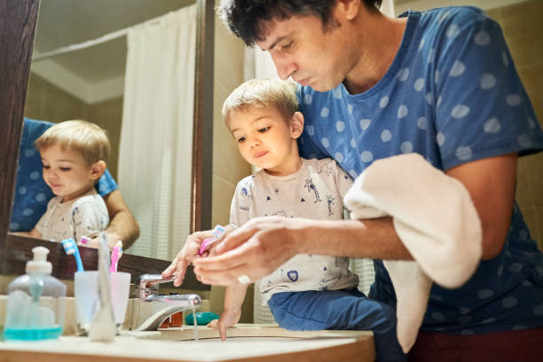 istock Rinsing toothbrush in sink 1194317838