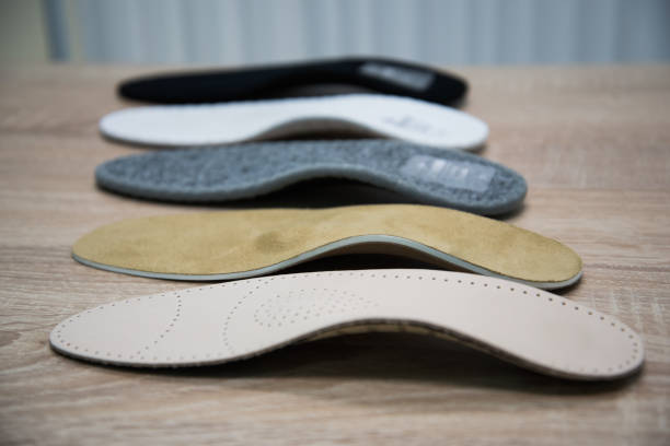 samples of different orthopedic insoles. insole with a variety of coating Orthopedic insoles are lined up on a wooden surface. samples of different orthopedic insoles. insoles with a variety of coating. inserting stock pictures, royalty-free photos & images