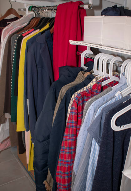 istock Rail with multi-colored clothes on hangers and in containers. Open storage system 1194319271