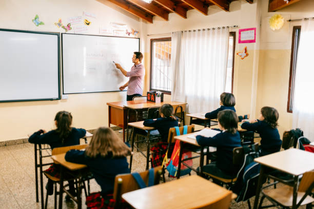 istock Primary School Teacher working with students in Classroom 1194319986