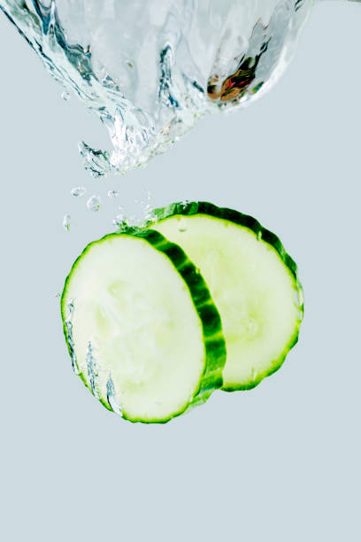 istock Two cucumber slices falling into the water 1194321119