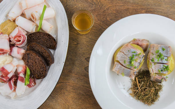 istock Top view, 2 dishes with appetizers: bacon, black bread, herring, potatoes, tincture. 1194321291
