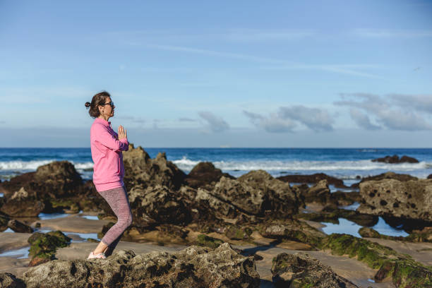 istock Brunette woman practicing yoga on the beach 1194322053