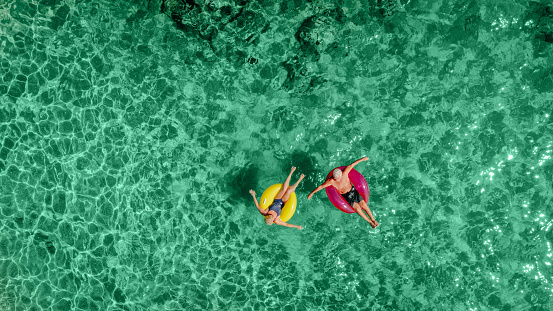 Photo of a senior couple on inflatable rings in the sea