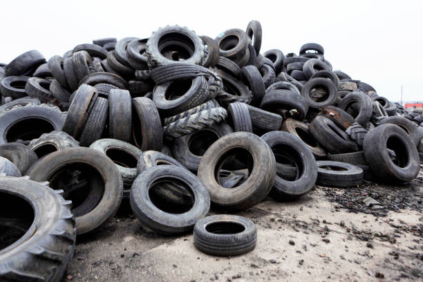 Industrial landfill for the processing of waste tires and rubber tires. Pile of old tires and wheels for rubber recycling. Tyre dump stock photo