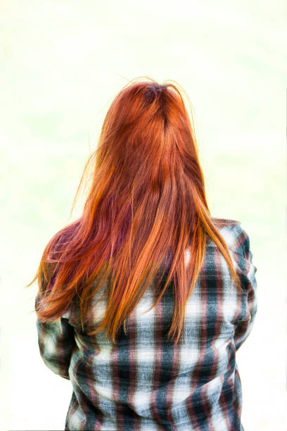 istock Young red haired woman with back turned to camera. 1194324074