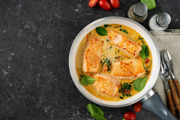 istock Delicious salmon steaks in cream sauce on black background 1194324862