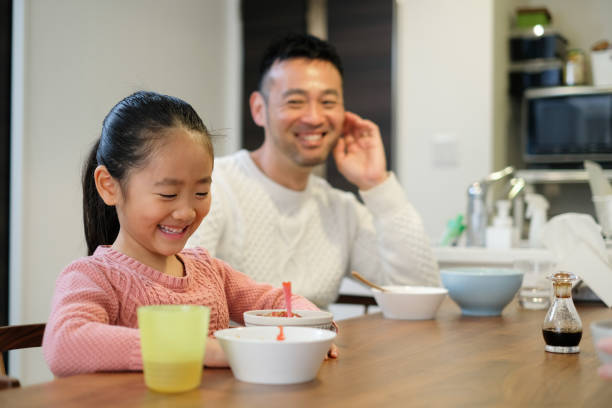istock Father and daughter eating meal at home 1194324949