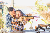 Mixed Race Father And Son At Fairground Shooting Range
