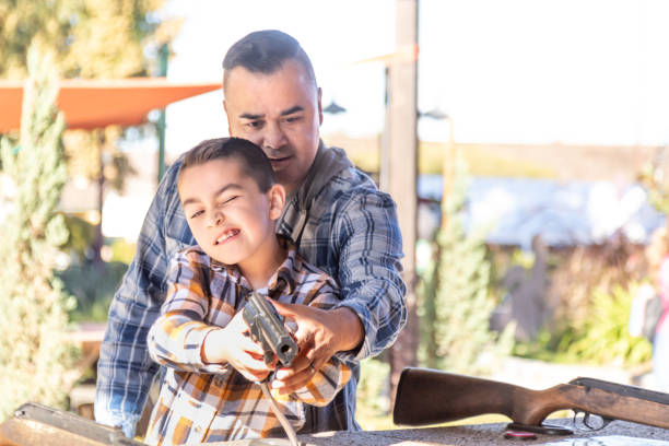 Mixed Race Father And Son At Fairground Shooting Range.