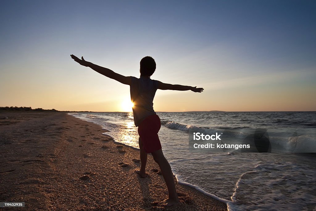 10 代の少年のビーチ日没瞑想する - 1人のロイヤリティフリーストックフォト