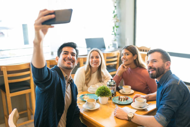 istock Man Taking Selfie With Friends At Cafe Table 1194330061