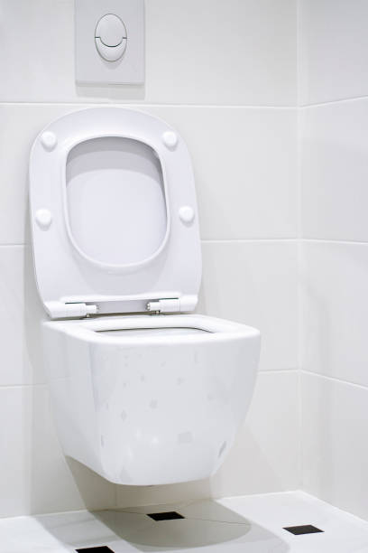 istock Interior. A white toilet bowl hangs on a white tile wall in a white bathroom 1194331802