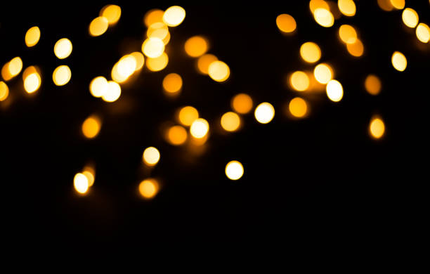 istock Blurred background. Christmas lights on a black background. Yellow light bulbs. 1194331877