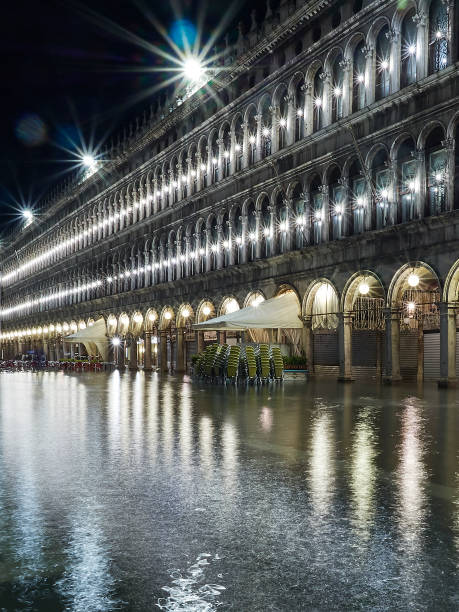 plaza san marco por la noche en venecia italy se inundó durante la marea alta de acqua alta en noviembre, consecuencia del cambio climático y el calentamiento global, el aumento de los niveles de agua - acqua alta fotografías e imágenes de stock