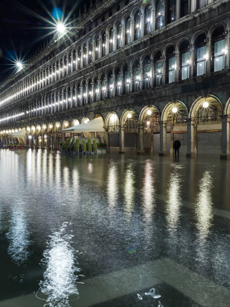 san marco carré la nuit à venice italy inondé pendant acqua alta marée haute en novembre, conséquence du changement climatique et le réchauffement climatique, la hausse des niveaux d'eau - acqua alta photos et images de collection