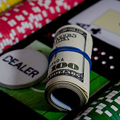 ein 100 dollar kupurs ist auf dem blackjack tisch neben poker chips und einem dealer chip