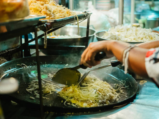 麺の炒め物である「パッタイ」と呼ばれる有名なタイのストリートフード料理を調理し、 - thailand thai culture thai cuisine pad thai ストックフォトと画像